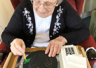Silverpoint Court lady resident scratching a craft egg design