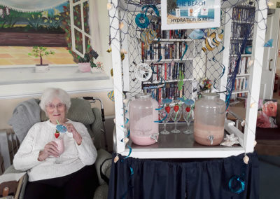Silverpoint lady resident sitting by the milkshake trolley with a milkshake in her hand