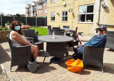 Silverpoint Court residents having a socially distance visit from a loved one outside in the garden