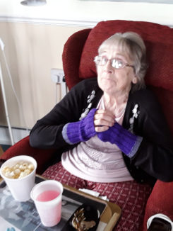 Resident with a drink and popcorn, enjoying a film at Silverpoint Court