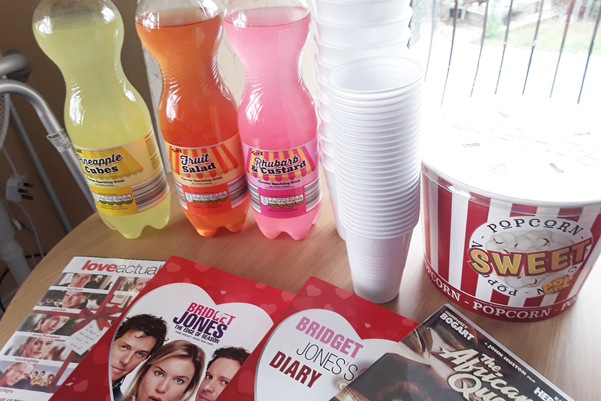A medley of drinks, popcorn and DVDs on a table
