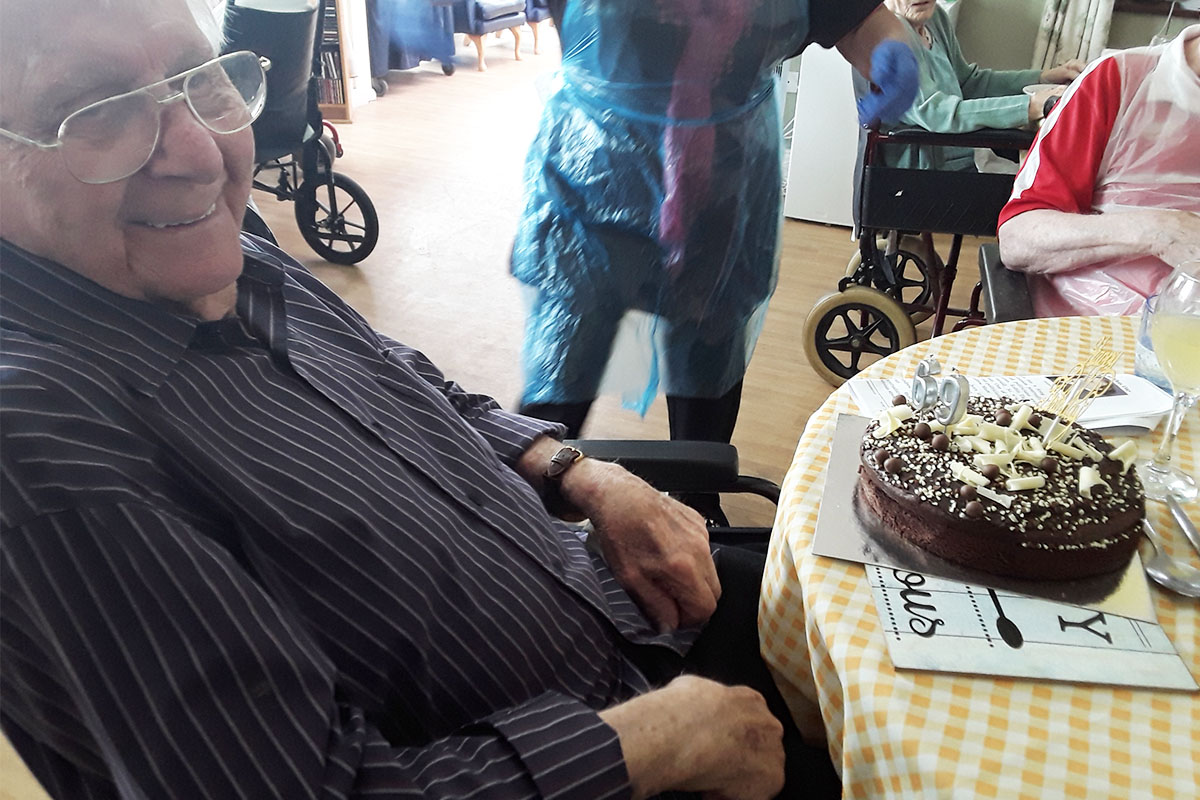 Silverpoint Court Residential Care Home resident smiling at the camera with his chocolate birthday cake