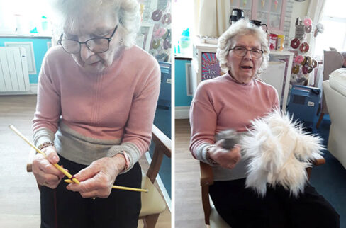 Sylvia knitting and brushing a toy dog Silverpoint Court Residential Care Home